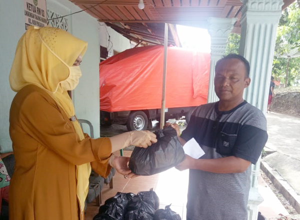 Anggota DPRD Rokan Hulu Fraksi Golkar, Hj Hasmeri Yulinawati menyerahkan sembako kepada salah satu masyarakat di Kecamatan Rambah