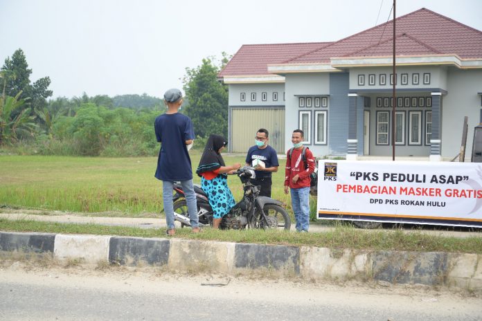 anggota DPRD Rokan Hulu, dari fraksi PKS, H Depredi Kurniawan saat membagi masker kepada masyarakat