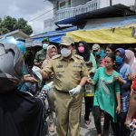 Bupati Rohul H Sukiman memberikan masker gratis yang disalurkan PMI Rohul kepada pengunjung Pasar di Kecamatan Ujung Batu