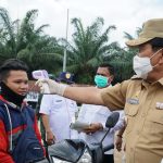Bupati Rohul H Sukiman langsung melakukan thermo screning kepada salah seorang pengendara sepeda motor, saat meninjau kondisi Posko Covid-19 yang didirikan di daerah perbatasan pintu masuk kabupaten Rohul